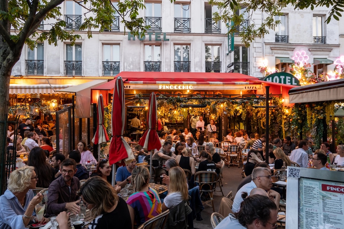 Terrasse animée de restaurant italien Pinocchio à Montparnasse avec une clientèle de professionnels parisiens en soirée