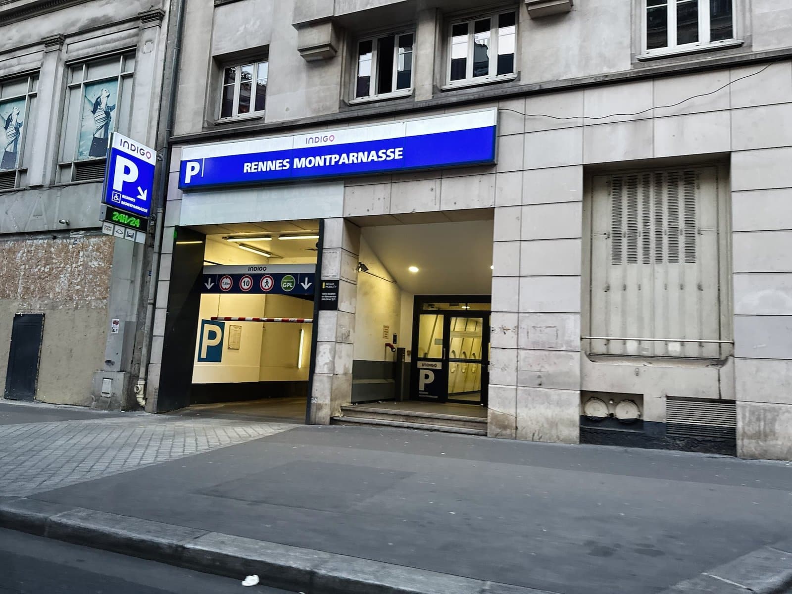 Entrée d’un parking souterrain du quartier Montparnasse, sous un bandeau bleu « Rennes Montparnasse »